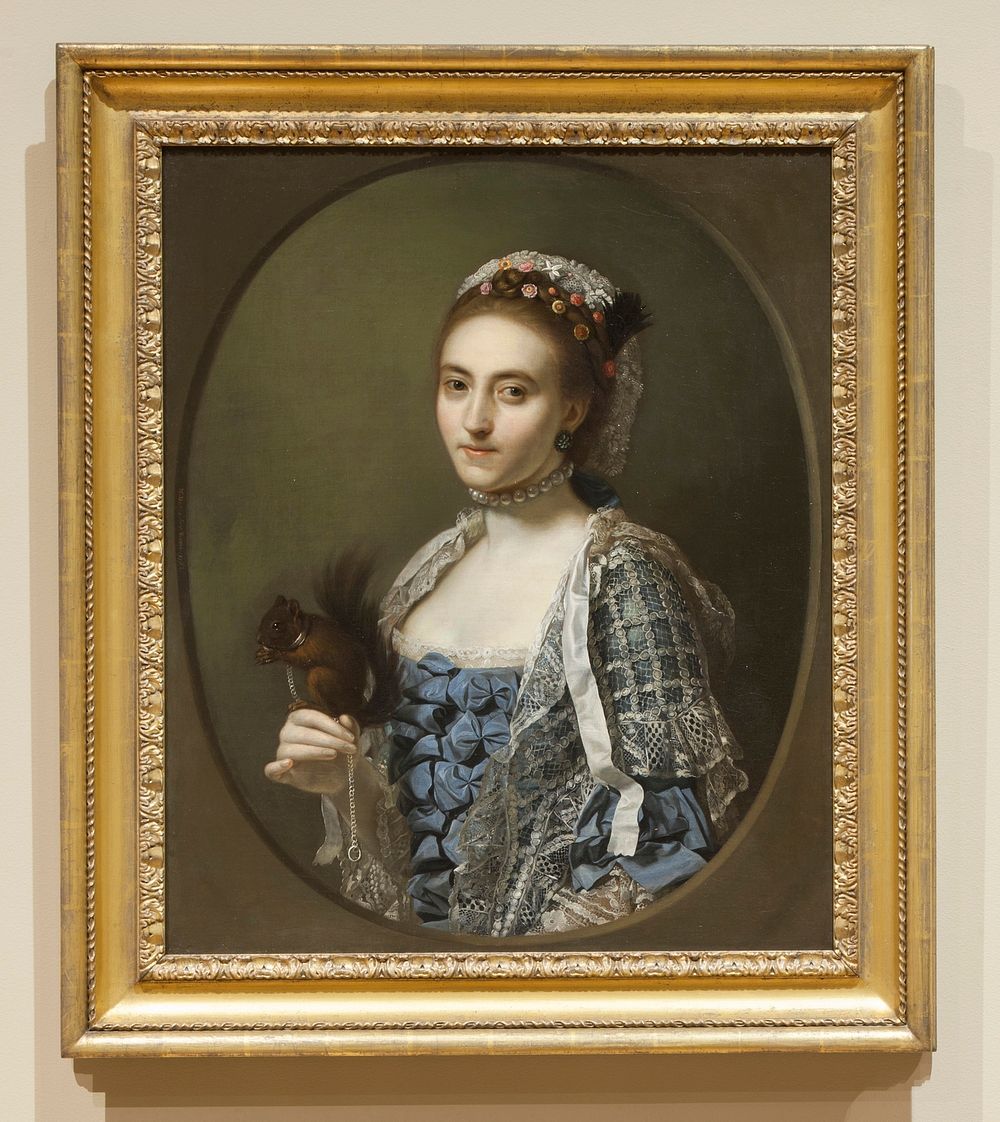 portrait of a young woman wearing a choker of large pearls, a blue dress with bows on the bodice and white lace netting and…