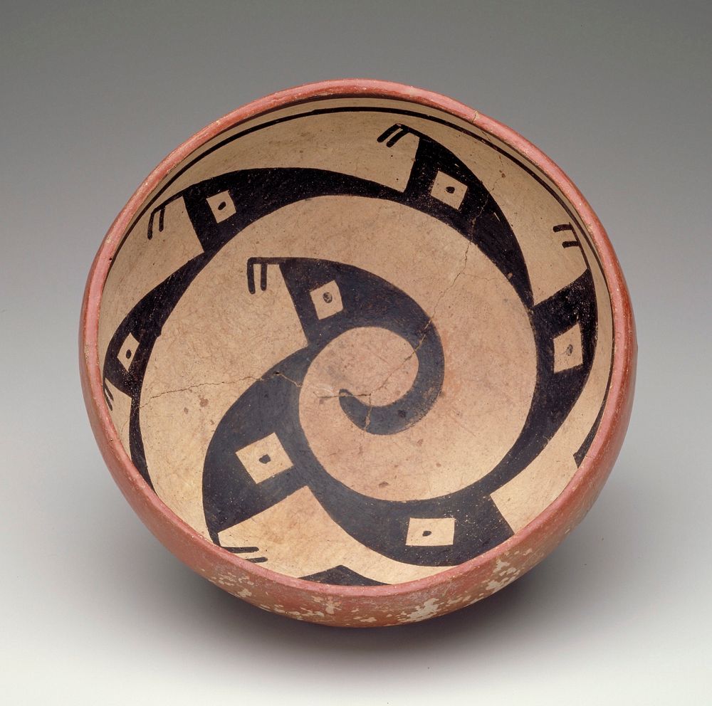 bowl with rounded bottom; red on exterior; interior decorated with a black spiraling figure with geometric designs on a…