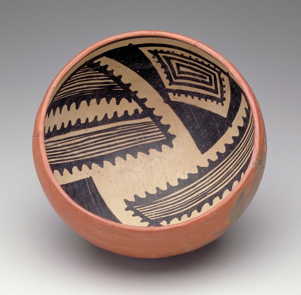 bowl with rounded bottom; red on exterior; interior decorated with 4 black triangles, filled with geometric patterns, on a…
