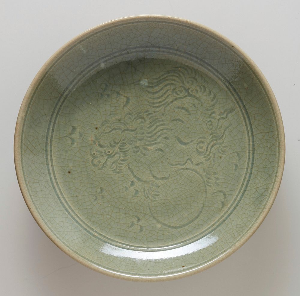 plate, footed, with incised design of foo dog at center and lotus petal motif circling foot; celadon, ceramic, maker Hsien…