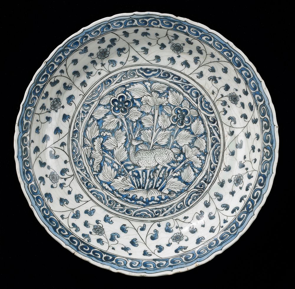Dish, Meshed ware, Safavid Dynasty, early XVII Century. White earthenware with underglaze blue and black decor. Central…