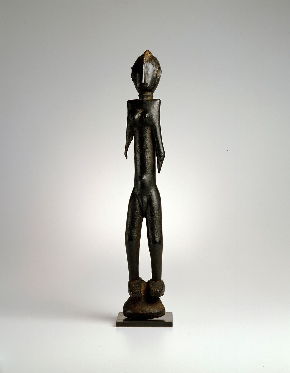 standing female figure; wood; from a 'Karan-Wemba' mask, with heavy encrustation and showing faint lines of body…