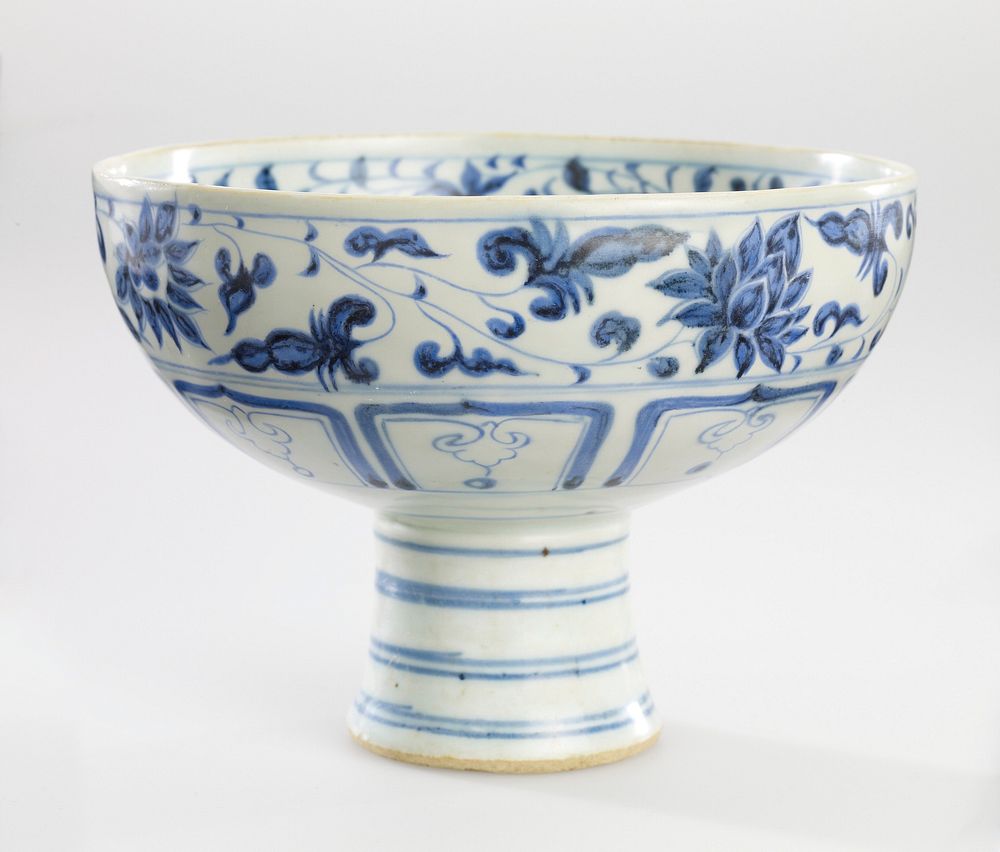 blue and white glaze; bowl on a tall, slightly flaring stem; foliate spray at center; foliate bands on interior and exterior…