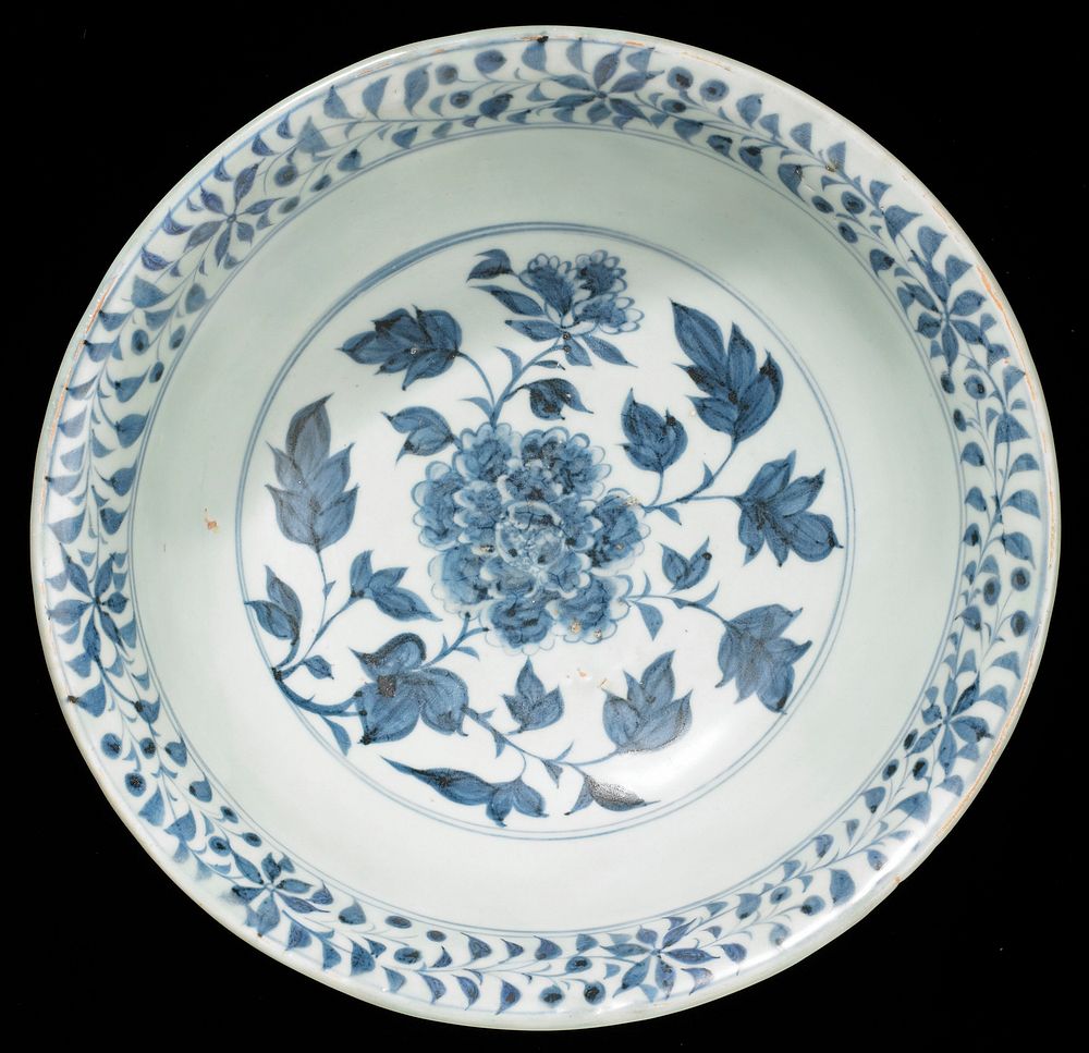 blue and white glazed bowl decorated with large central floral sprays; foliate bands on outer and inner rim and organic and…