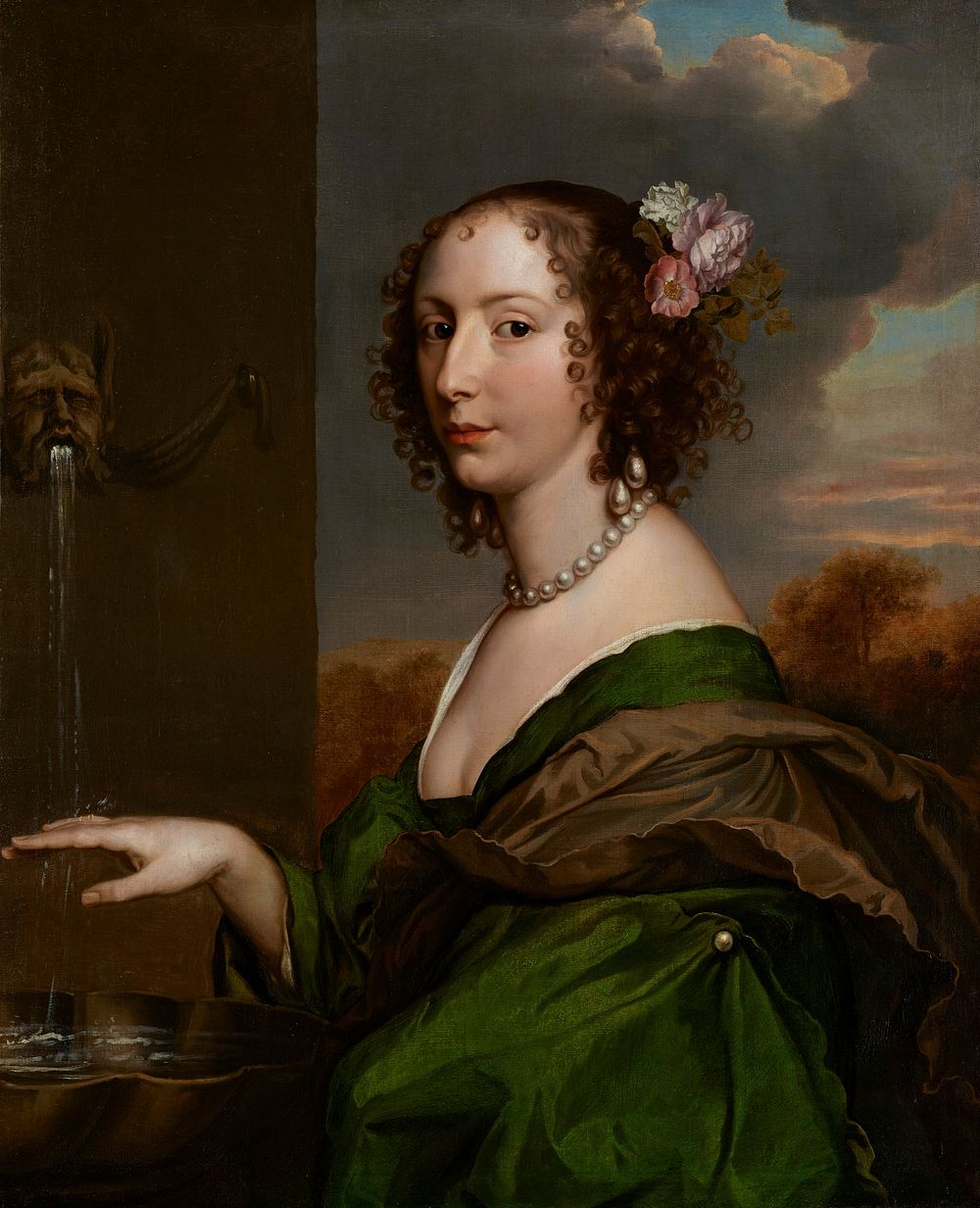 Portrait of a woman in a green dress and brown scarf with flowers in her hair, pearl necklace and earrings, at a fountain..…