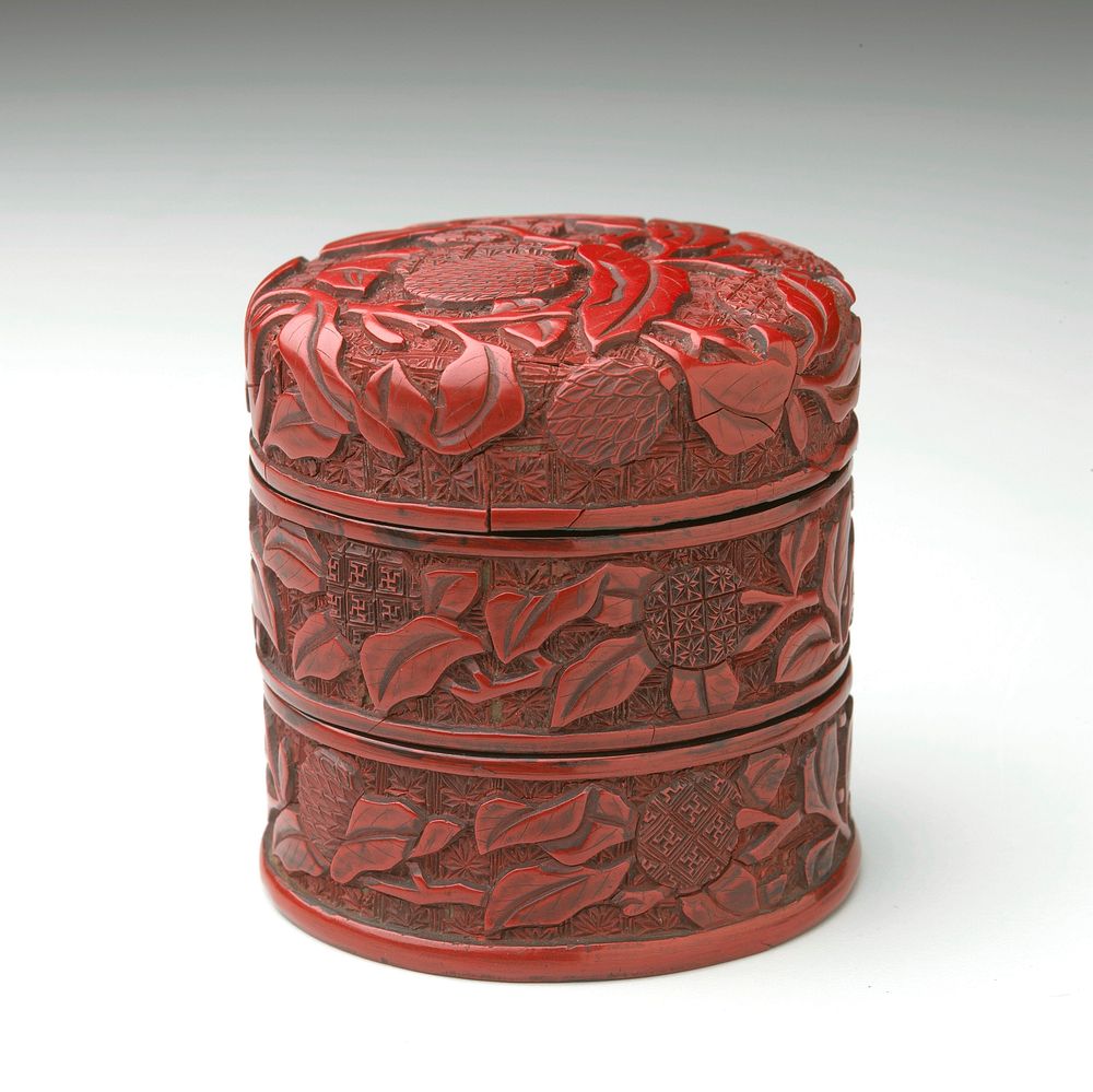cylindrical form with slightly domed cover; carved overall with lychee against a patterned ground. Original from the…