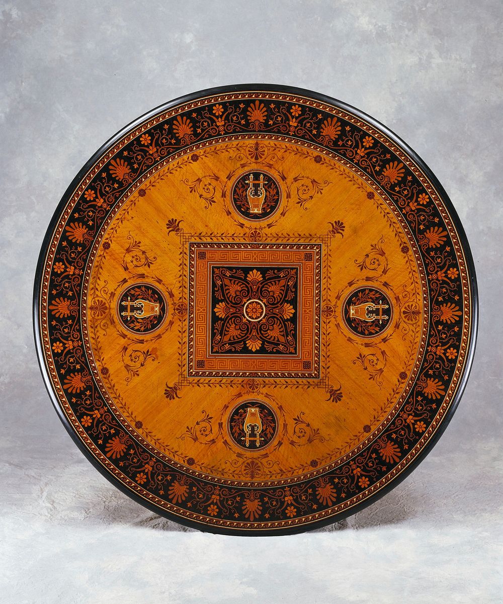 circular inlaid table with four footed pedestal base; central square organic motif with banding of meandering pattern and…