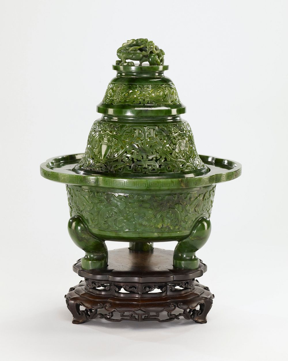 Censer, covered, of green jade in the form of a pagoda. The cover is in 3 sections carved with Buddhist symbol ; the finial…
