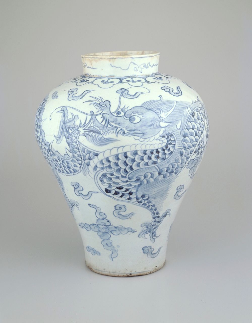 wide, flaring shoulder with short, wide neck; blue and white glaze with 2 dragons, cloud forms and scrolls around neck.…