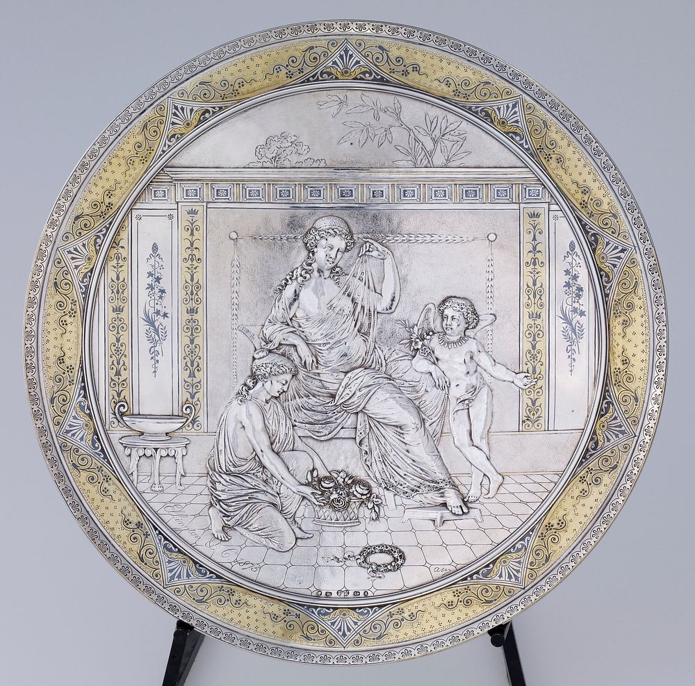 concave, plate-like shape; relief design of seated woman wearing a gauzy drape in an interior; putti with flowers wearing a…