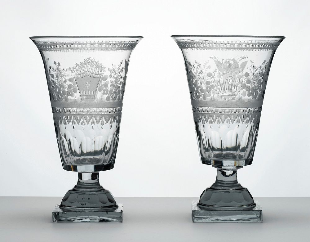 outward-flaring footed clear vase on a square base; cut glass designs of flowers and swags, urns and a pair of birds on a…