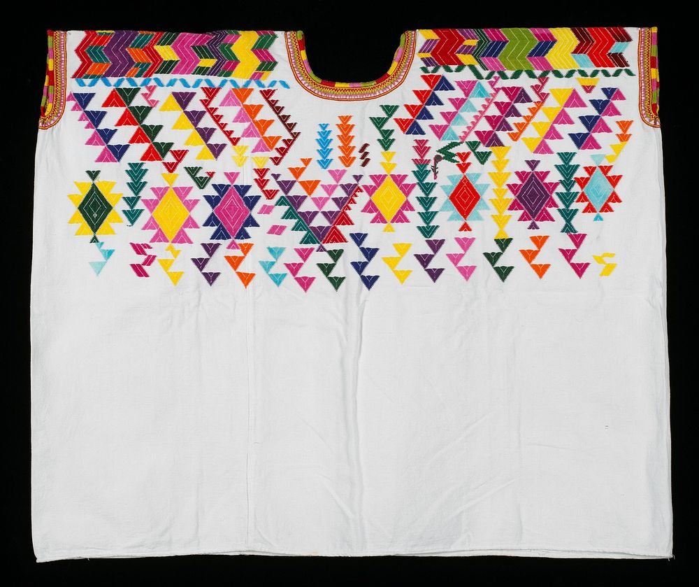 White, two-paneled cotton huipil with multicolored embroidery of abstract geometric patterns in turquoise, yellow, blue…