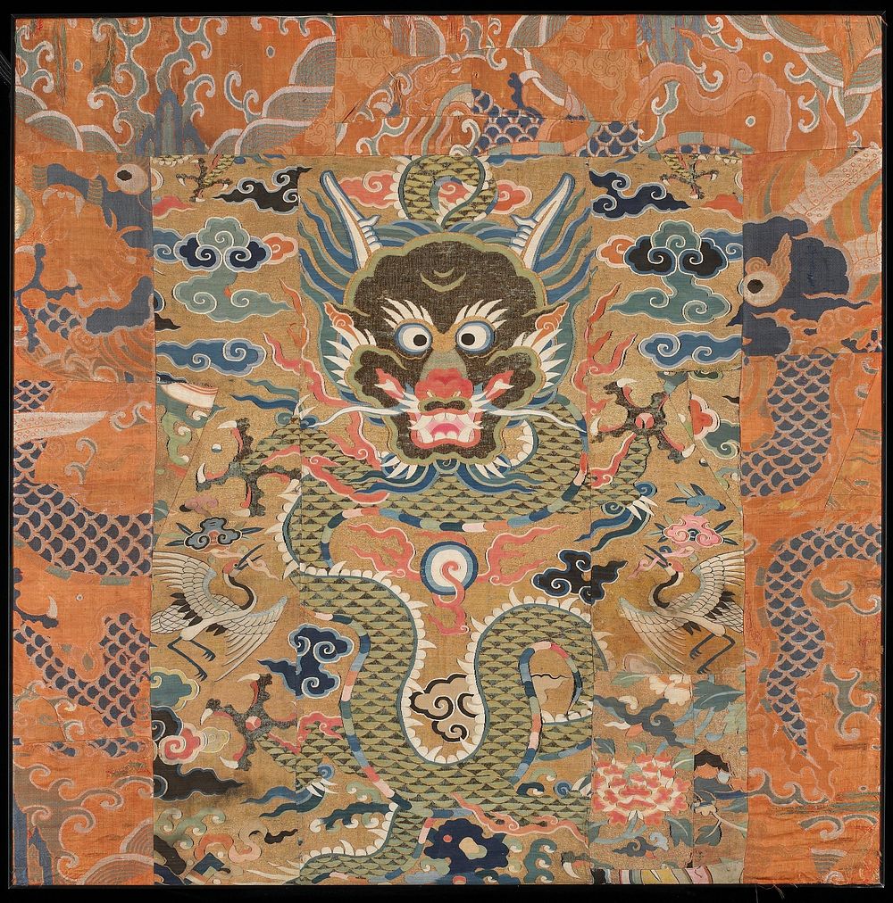 Fragments of at least two textiles sewn together; large-headed dragon at center surrounded by clouds and birds; orange and…
