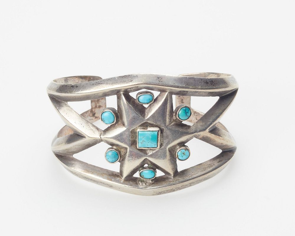 cast openwork band; set with one square and six round Nevada turquoises; star design. Original from the Minneapolis…
