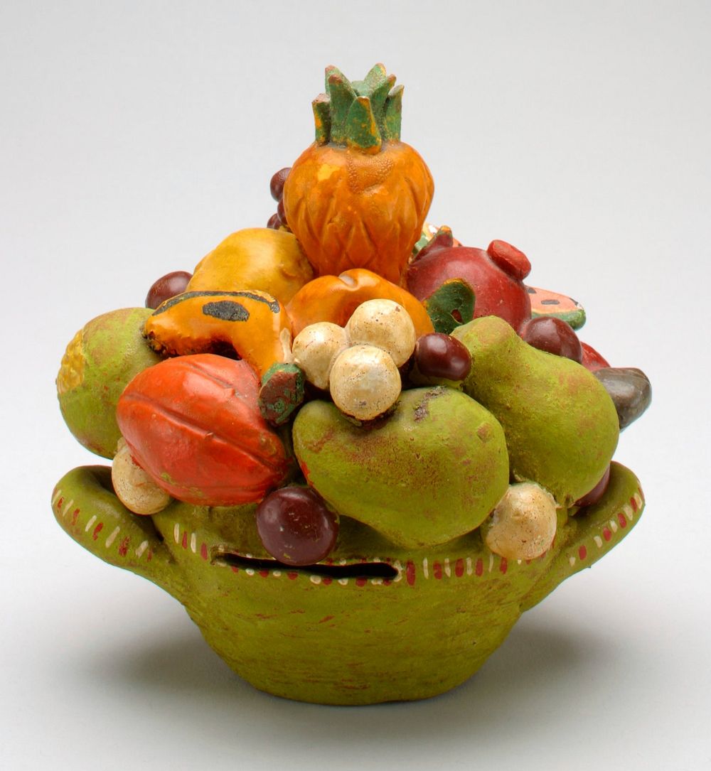 green ceramic basket filled with a variety of fruit; coin slot in basket edge;. Original from the Minneapolis Institute of…