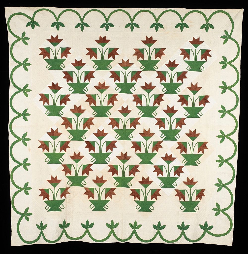 pieced blocks with design of three brown flowers in a green two-handled container; green scallop and leaf border; cream and…