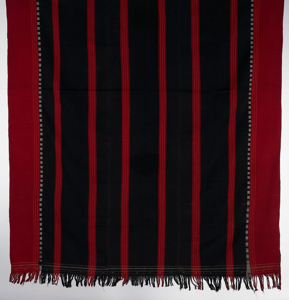warp face; plain weave; black with red borders and six red stripes running through the length; small patterning and fringe…