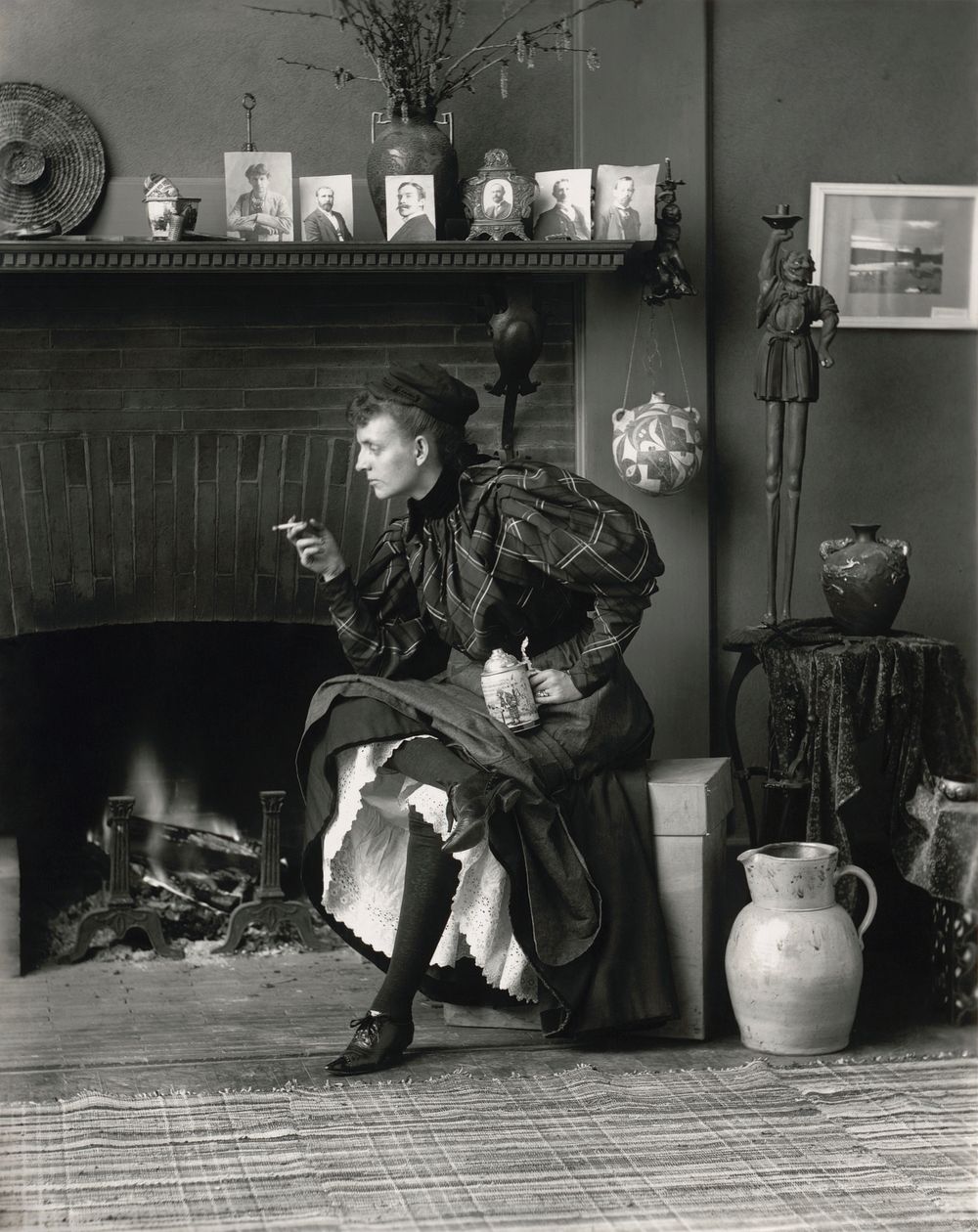 Frances Benjamin Johnston's Self-Portrait (as "New Woman"), a full-length self-portrait of her seated in front of fireplace…