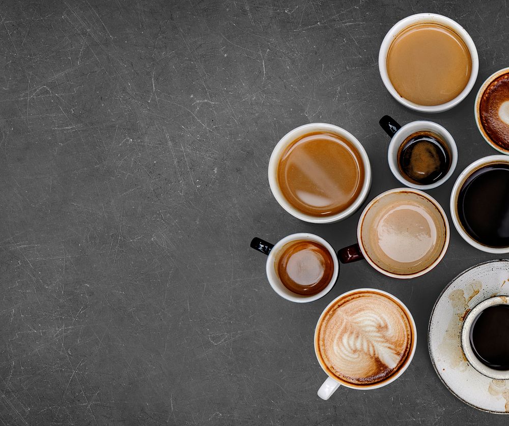 Mixed coffee mugs on a black textured background