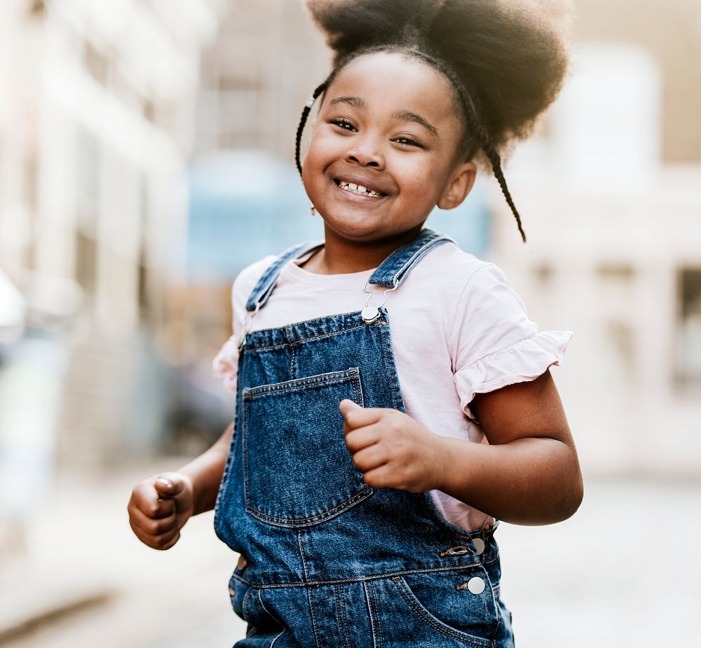 Happy African-American girl running on the street