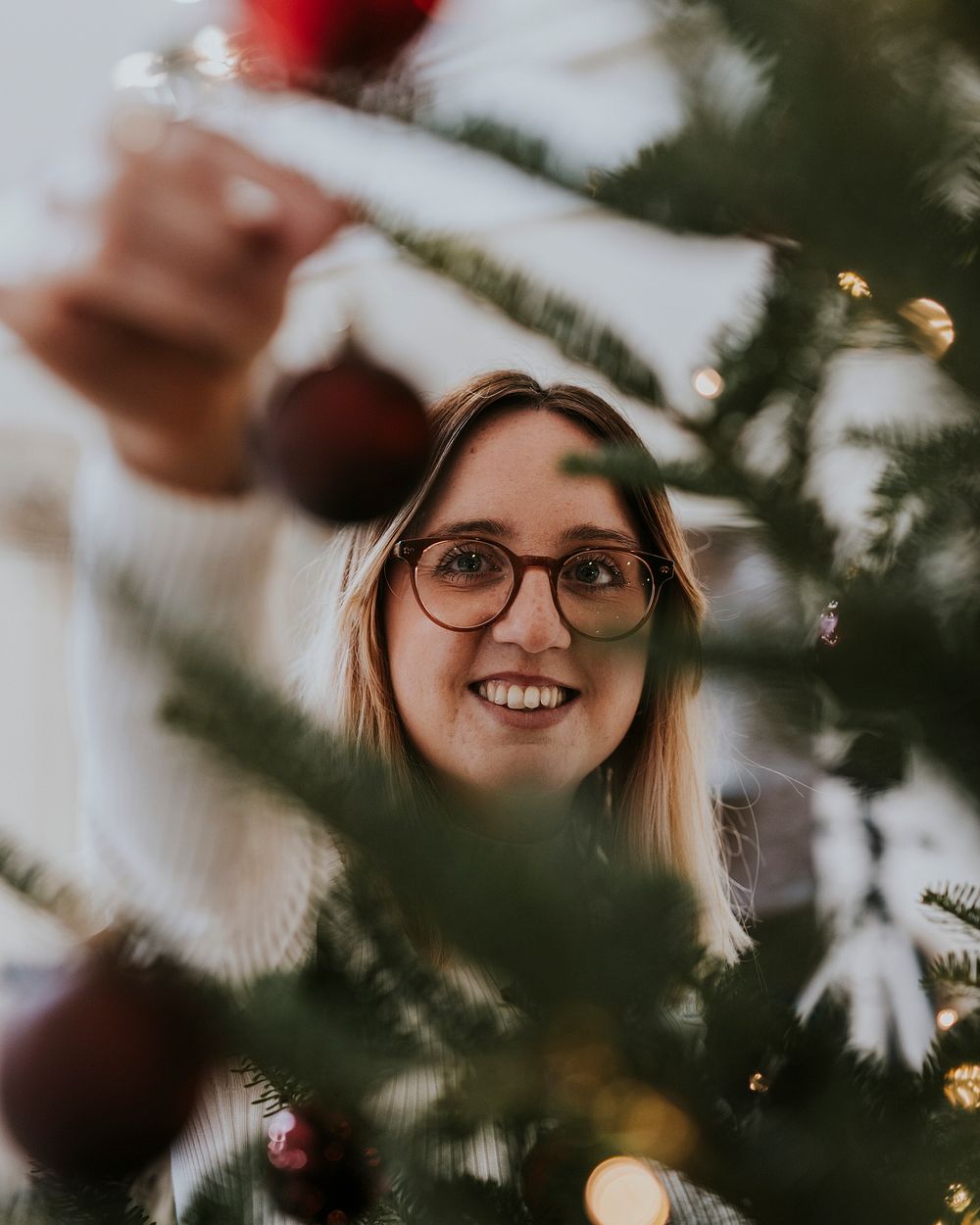 Happy woman decorating Christmas tree