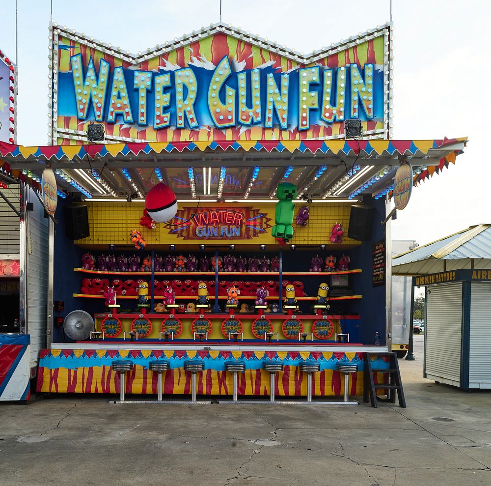                         Carnival-style shooting-gallery game booth like this one in which the guns are water pistols, at the…