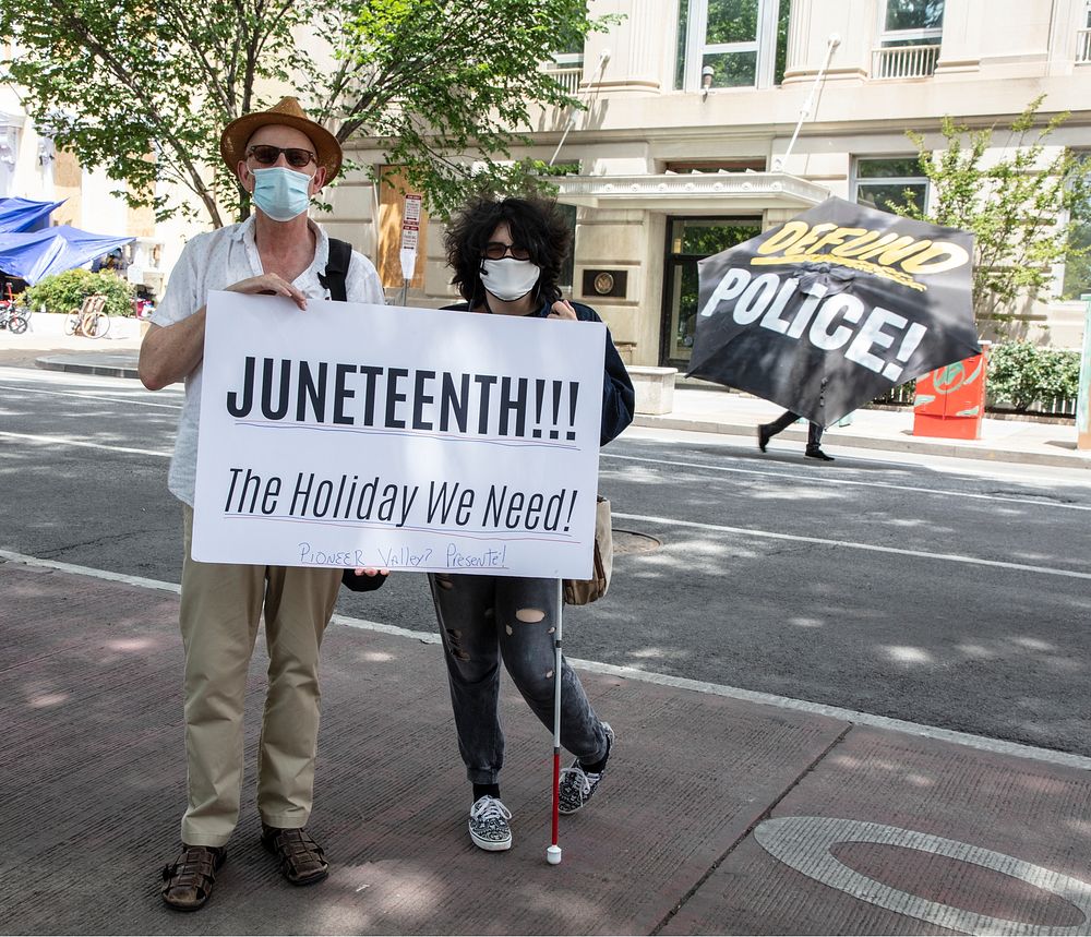                         Joe and Arlo Gannon pose with a Juneteenth sign about a block from the White House on Juneteenth, a…