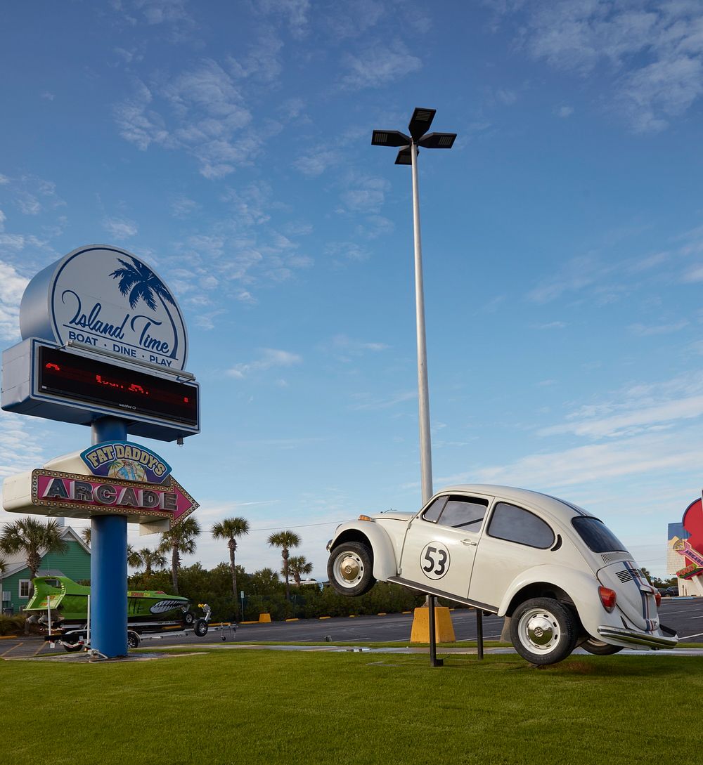                         Sign and an unexplained vintage Volkswagen Beatle displayed outside the Fat Daddy's Arcade in Fort…
