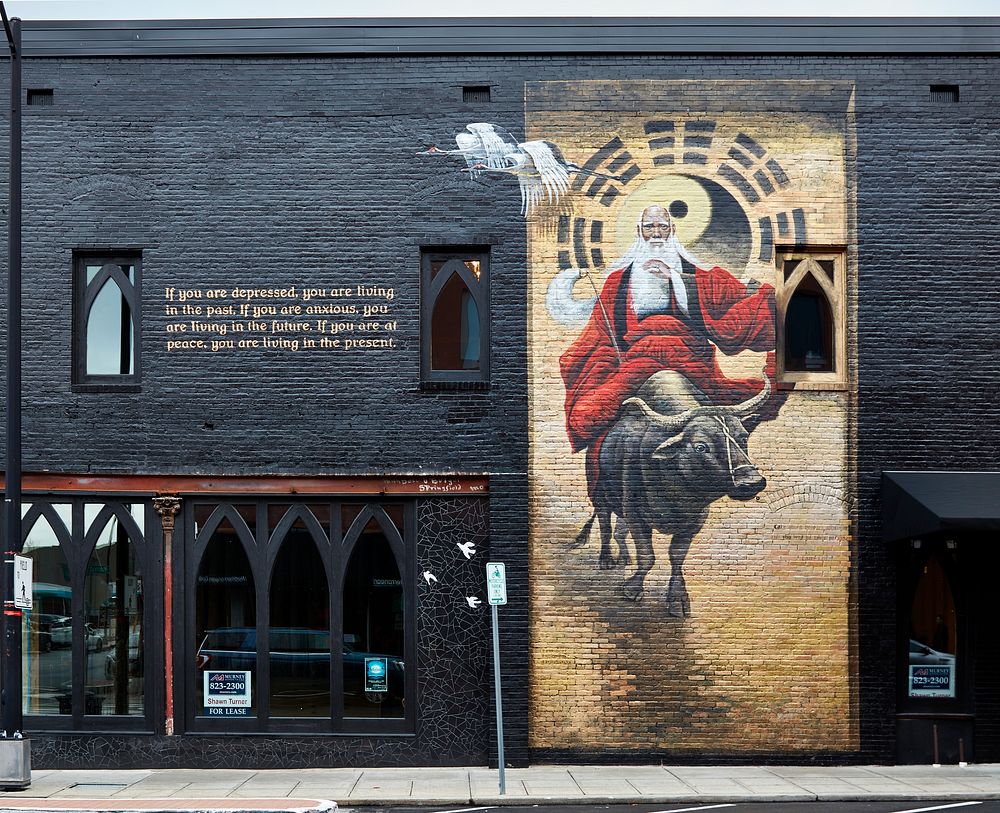                         This mural of a mystical-looking man on an ox, created by local artist Brad Noble with assistance…