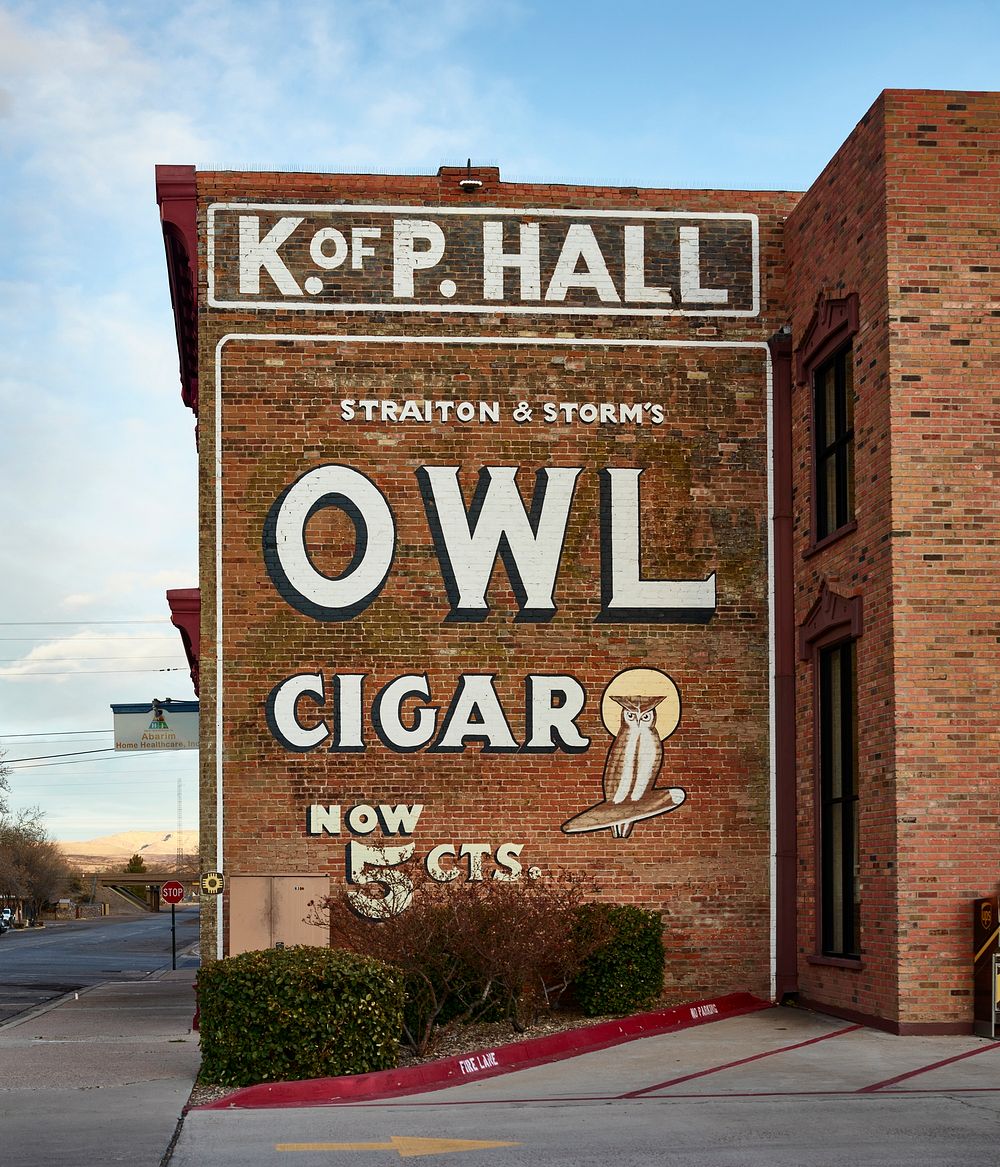                         A classic Owl Cigar advertising sign dominates a block of Socorro, a small city in central New…
