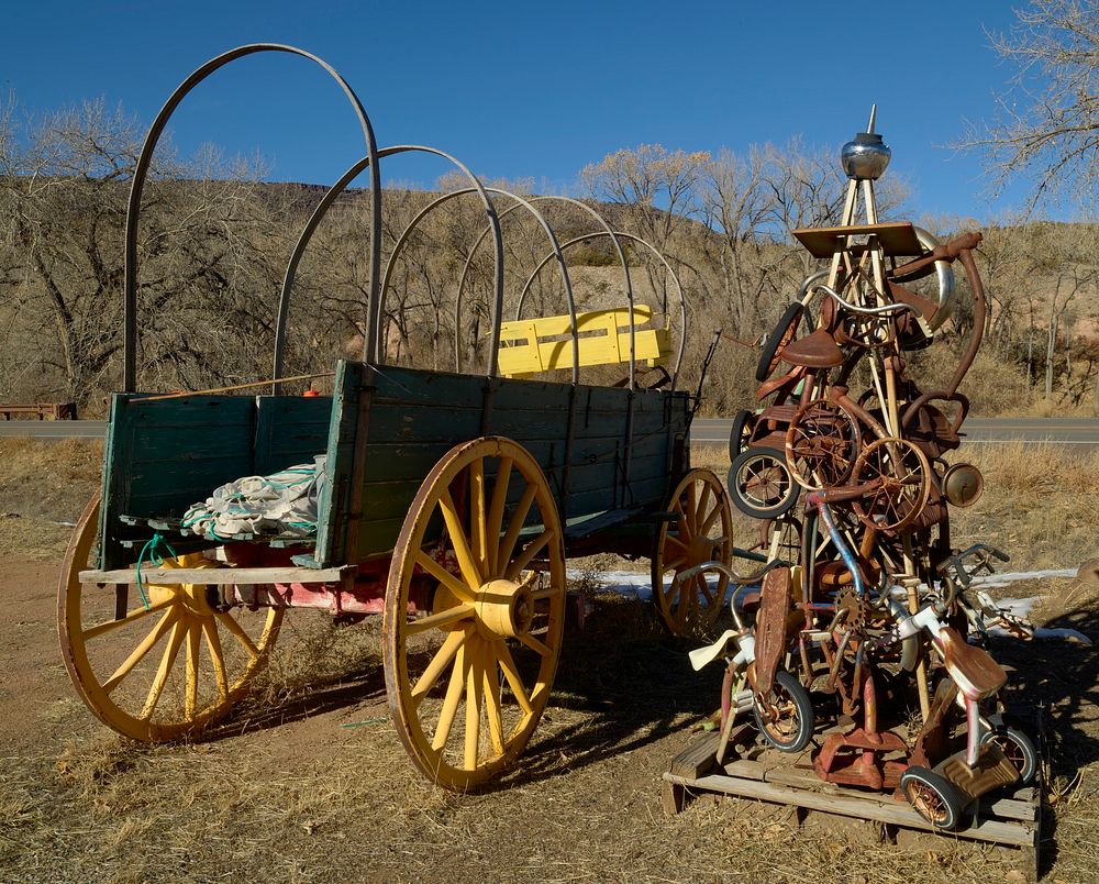                         A old wagon and a metal-art tricycle piece at a nostalgic roadside attraction, the Classical Gas…