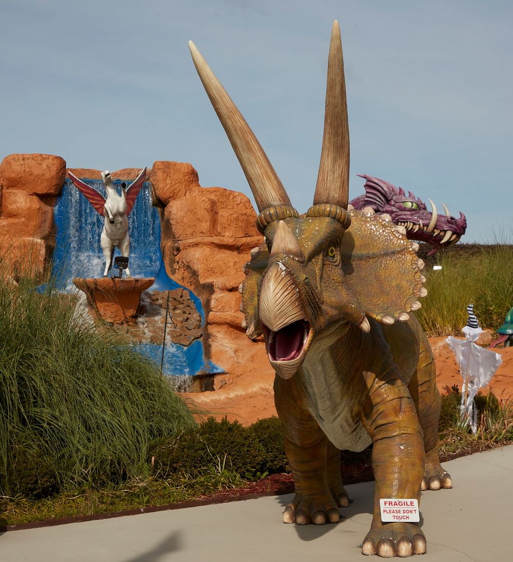                         All sorts of creature figures, including a prehistoric horned triceratops (foreground) overlook the…