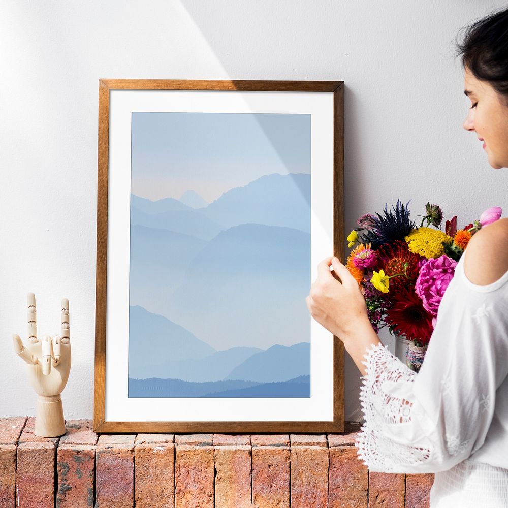 Woman decorating her home, picture frame on a wall