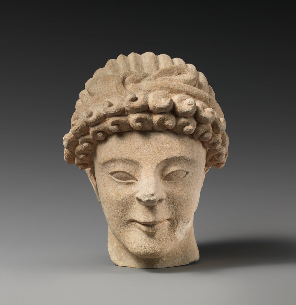 Limestone head of male votary with fillet