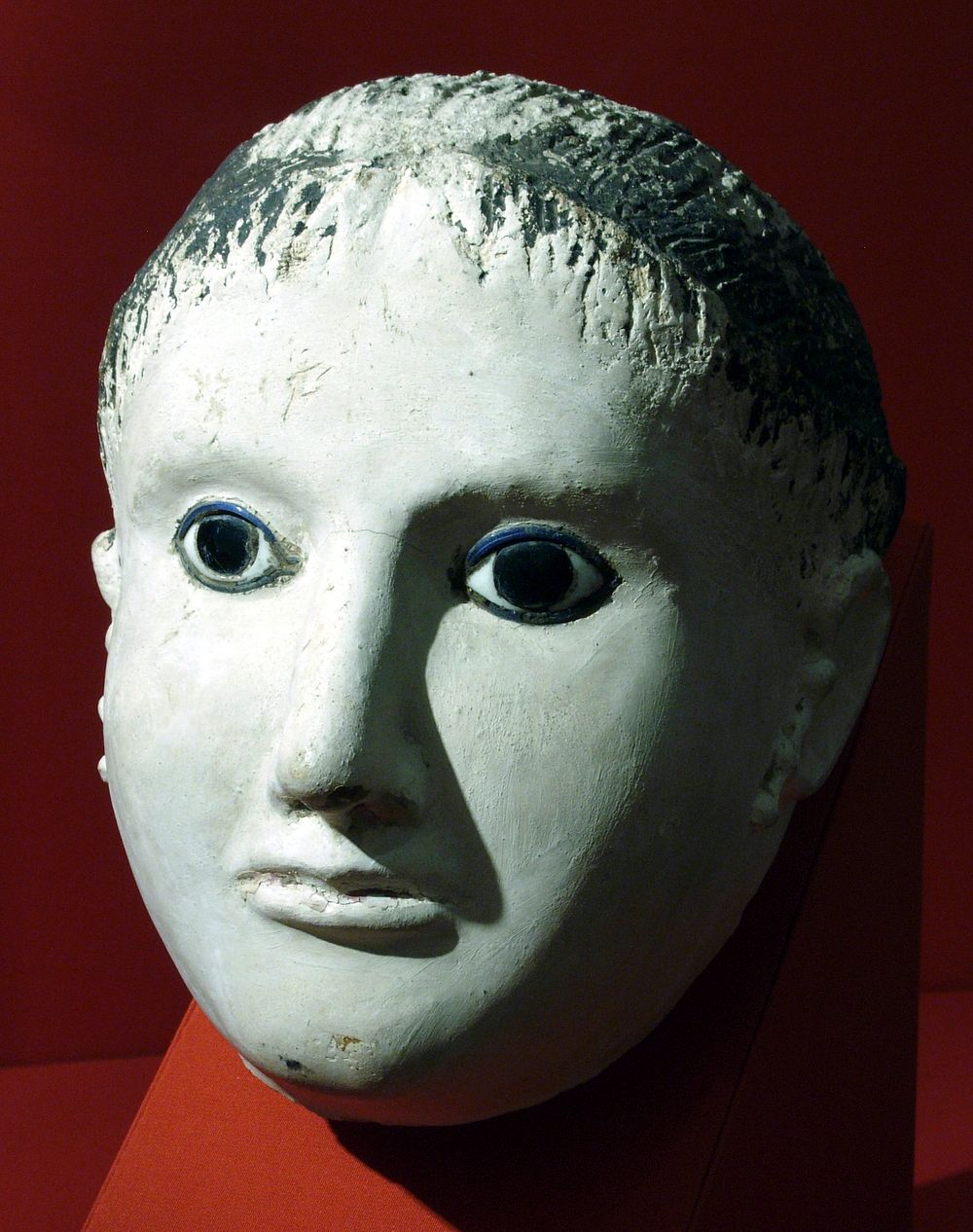 Mask of a woman with her hair rolled back at the forehead and temples
