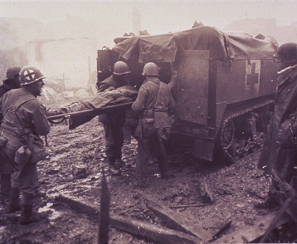 A wounded American soldier is loaded into a medic half-track (1944). Original public domain image from Flickr