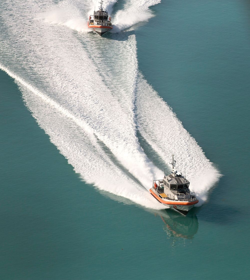 Two U.S. Coast Guard vessels patrol in tandem as they cruise over now calm, but murky, waters of the Florida Keys after…
