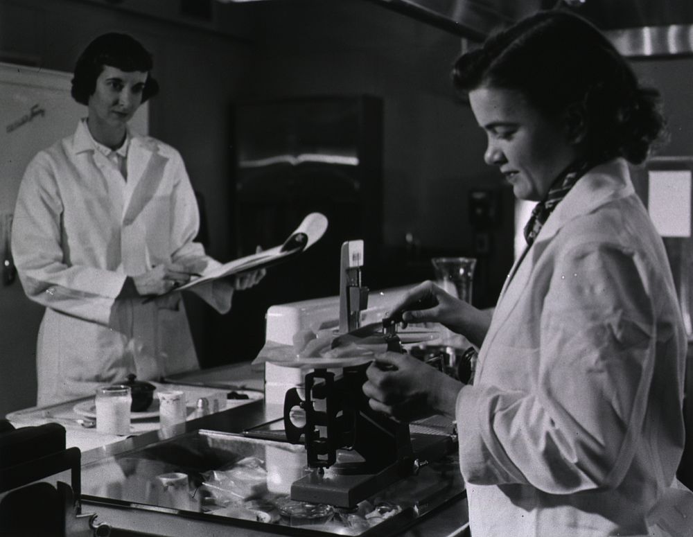 Two female dietitians weigh and measure foods before they are served to patients of restrictive diets. Original public…