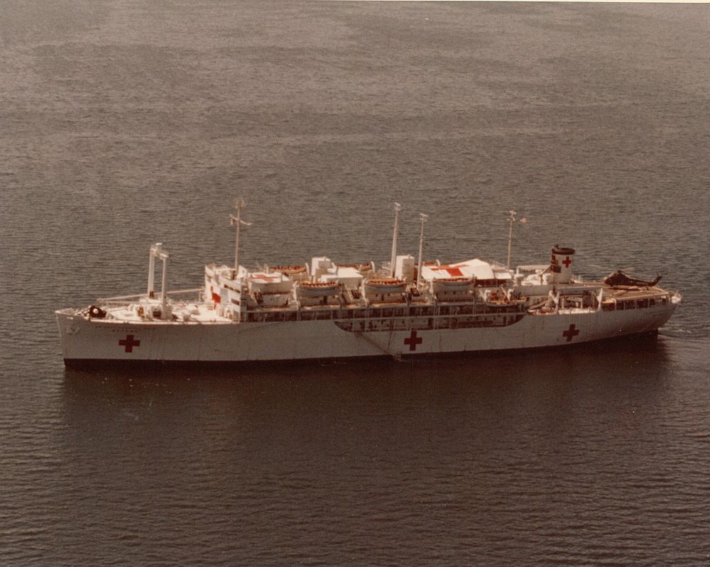 Aerial view of the hospital ship USS Repose (AH-16) in Danang Harbor with other units of U.S. Navy in the background. K…