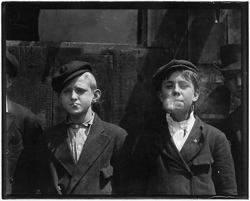 11:00 A.M. Newsies at Skeeter's Branch. They were all smoking. St. Louis, MO, May 1910. Photographer: Hine, Lewis. Original…