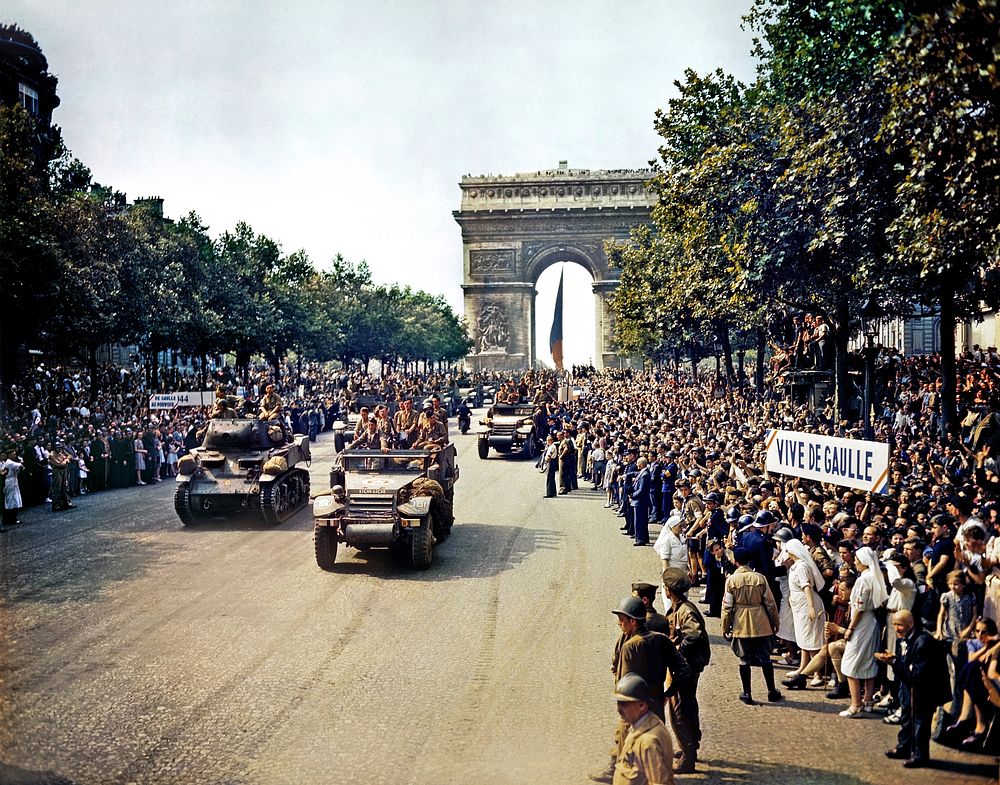 Crowds of French patriots line the Champs Elysees to view Free French tanks and half tracks of General Leclerc's 2nd Armored…