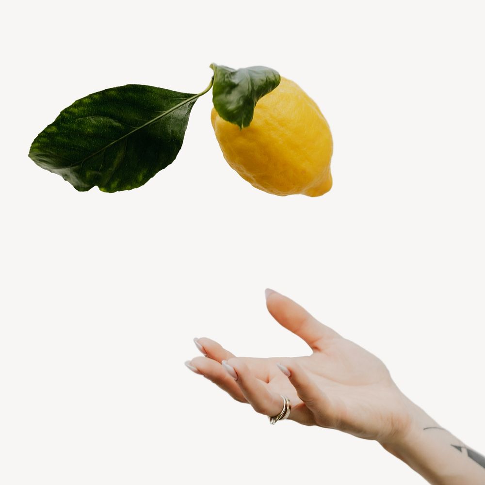 Hand catching floating fresh lemon