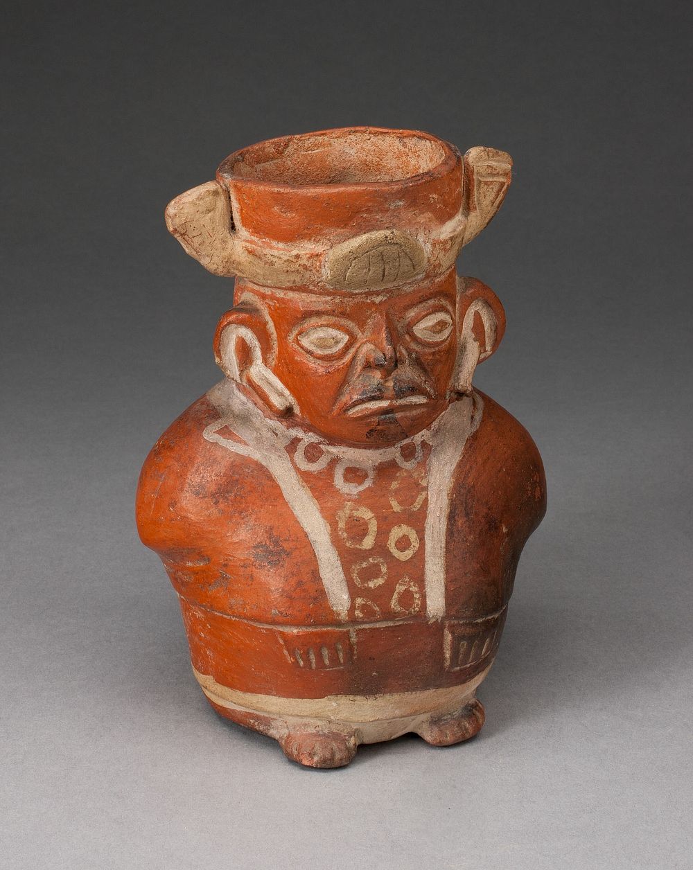 Jar in the Form of a Figure with Modeled Head and Painted Tunic by Moche