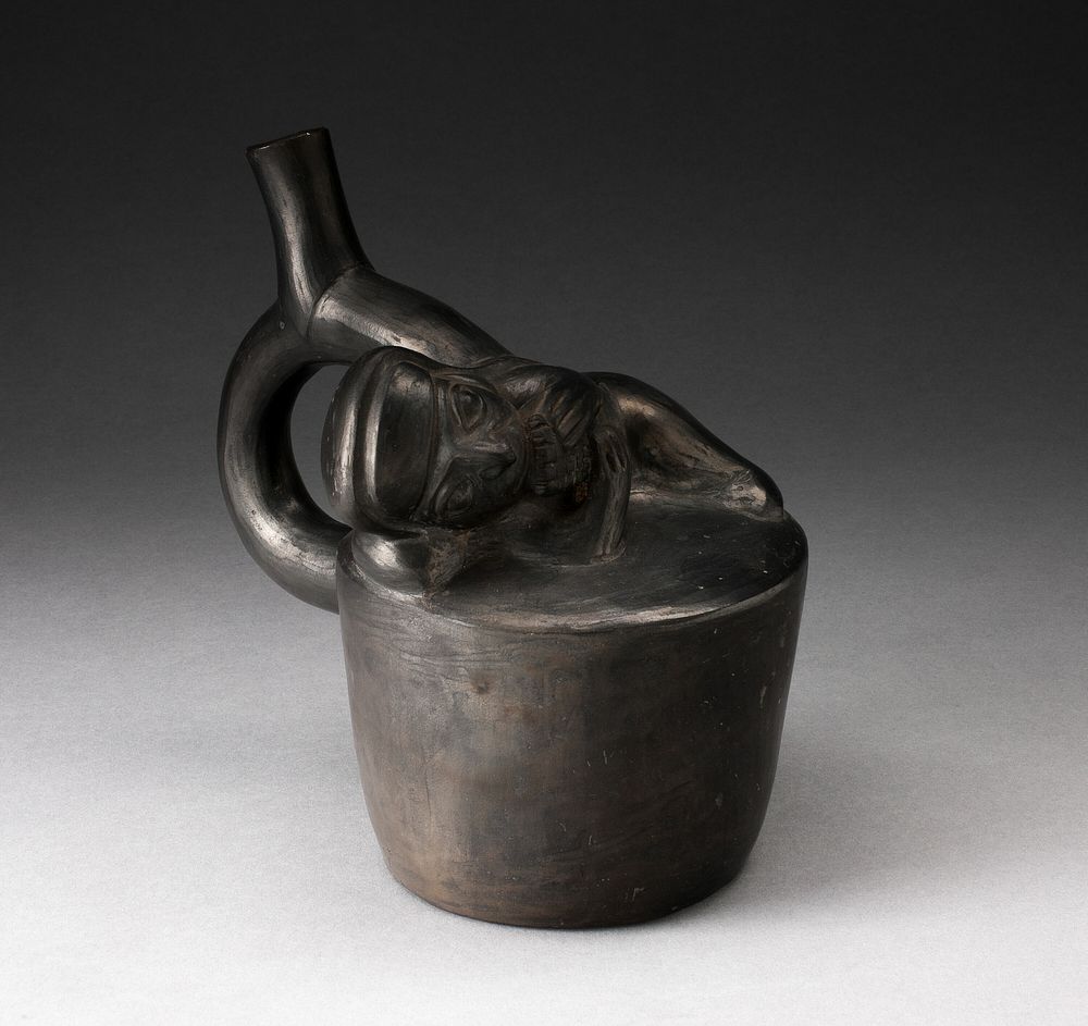 Blackware Handle Spout Vessel with Relief of a Reclining Musician with Pipes by Moche