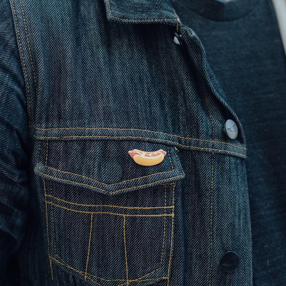 Cool hotdog enamel pin on a man's jean jacket.