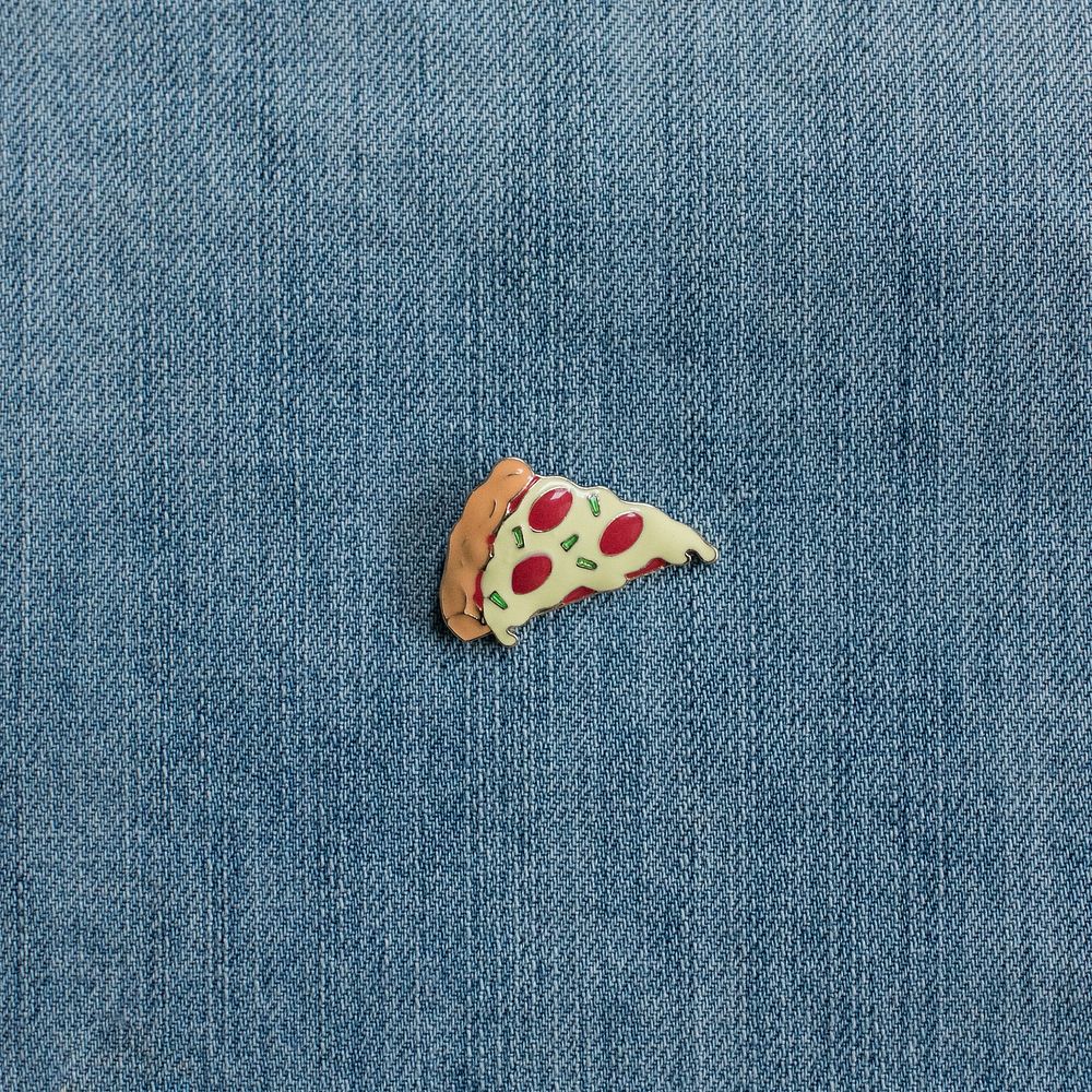 Pizza lapel pin on denim close up.