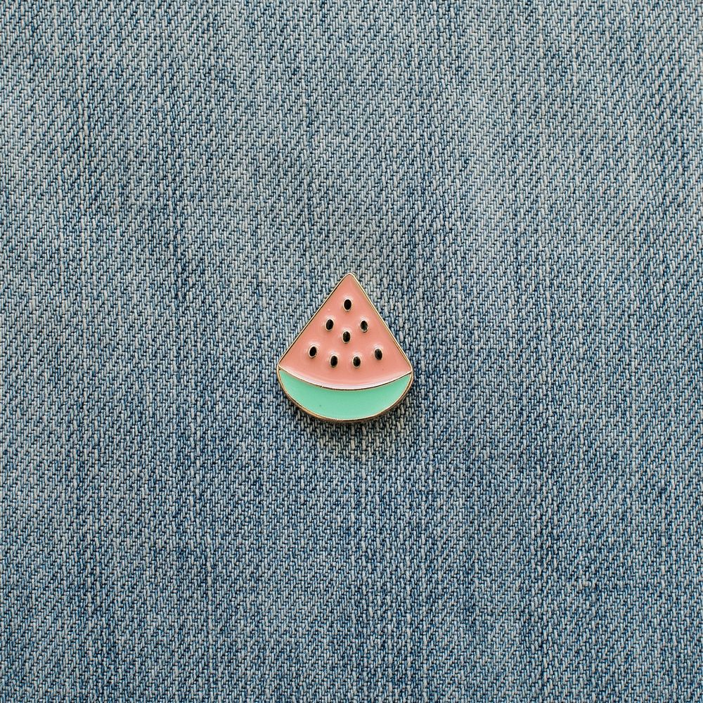 Watermelon slice enamel pin on denim close up.