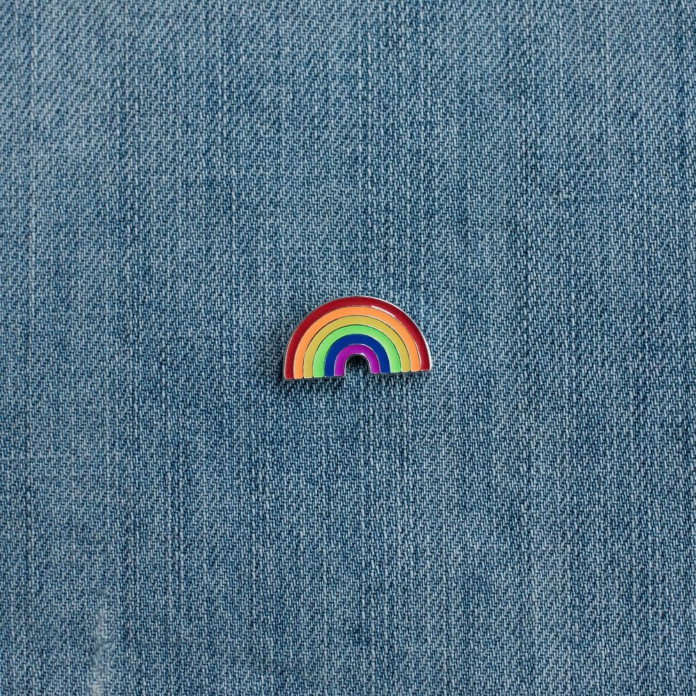 Rainbow enamel pin on denim.