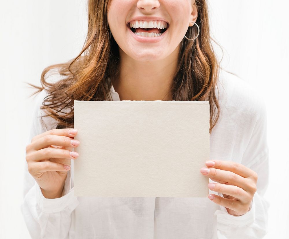 Cheerful woman showing a beige card mockup
