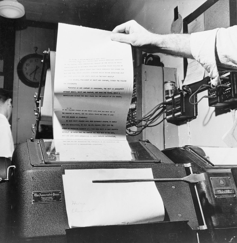 New York, New York. Wire room of the New York Times newspaper. Copy boy about to tear off dispatch coming over Associated…